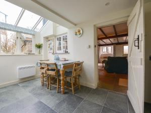 a kitchen and dining room with a table and chairs at 1 Gabberwell Cottages in Kingston