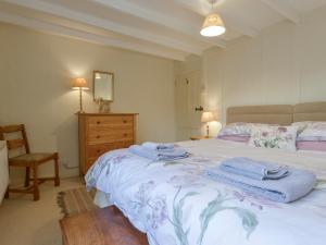 a bedroom with a bed with towels on it at 1 Gabberwell Cottages in Kingston