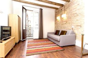 a living room with a couch and a tv at Apartments Barcelona Sagrada in Barcelona