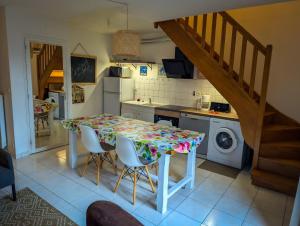eine Küche mit einem Tisch mit Stühlen und einer Waschmaschine in der Unterkunft Escapade cotentine in Montmartin-sur-Mer + 4 Fotos