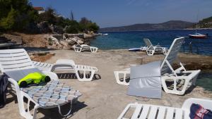 a group of lawn chairs and chairs on a beach at Spansa in Drvenik Veli +23 photos