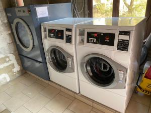 two washing machines and a washer and dryer in a room at Résidence Le Porto in Porto Ota
