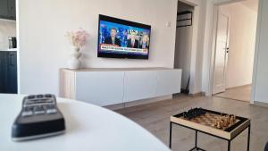 een woonkamer met een tv en een schaakbord bij Apartament przy basenie in Katowice