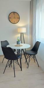 een tafel met twee stoelen en een tafel met een lamp bij Apartament przy basenie in Katowice