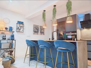 a kitchen with blue stools at a counter at Cuencaloft Ático Encantado Deluxe con Terraza in Cuenca