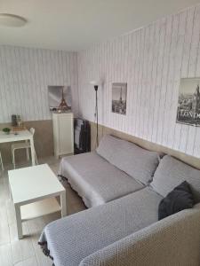 una sala de estar con dos camas y una mesa en Puerta del Sol II (Caleta de Fuste), en Caleta de Fuste