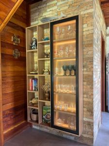a display cabinet with glasses in it in a room at Excelente Casa na Praia da Gamboa a 200 metros da Praia! in Garopaba