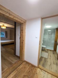 an empty room with a door open to a bedroom at Chata Wilczka in Miedzygorze
