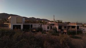 a house in the desert with mountains in the background at 20-30 Knots in El Sargento