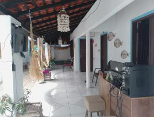 Una habitación con una mesa y sillas y un televisor. en Pousada Recanto do Mar, en Tutóia