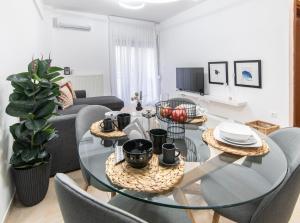 Una sala de estar con una mesa de cristal y sillas. en Best Point, en Alexandroupoli