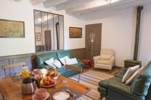 a living room with a green couch and a table at La Foutelaie in Clefs +27 photos
