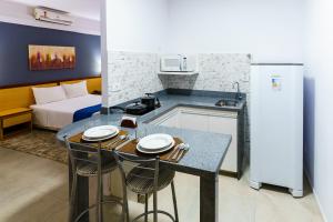 a kitchen with a table and two chairs in a room at Hotel Augusta Boulevard in Sao Paulo