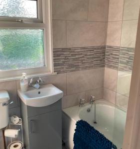 ein Badezimmer mit einem Waschbecken und einer Badewanne neben einem WC in der Unterkunft Chalets on Glan Gwna Holiday Park - Sleeps up to 10 in Caeathro