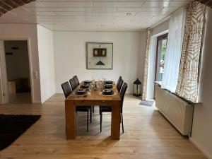 a dining room with a wooden table and chairs at Ferienwohnung Norderstedt in Norderstedt