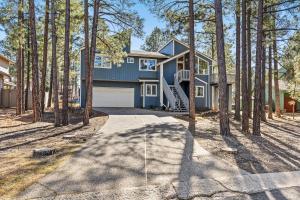 a house in the woods with a driveway at The Golfview Getaway in Flagstaff