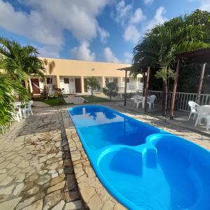 a pool in the backyard of a house with palm trees at Pousada Barra Mansa in Pitimbu