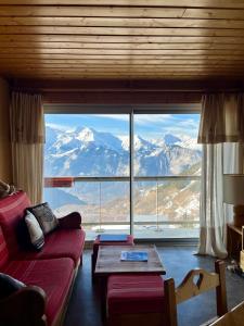 - un salon avec un canapé rouge et une grande fenêtre dans l'établissement T3 Plein Sud - Proche remontées mécaniques, à L'Alpe-d'Huez