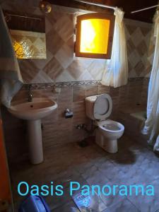 a bathroom with a sink and a toilet and a light at Oasis Panorama in Bawati