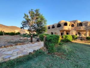 an old stone house in the middle of a field at Oasis Panorama in Bawati