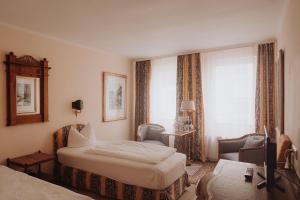 a hotel room with a bed and a chair at Pension Am Museum in Glückstadt