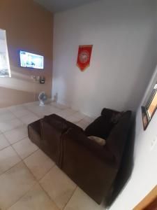 a living room with a brown couch and a tv at Casa MTB in Pirenópolis