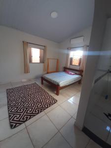 a room with a bed and a rug on the floor at Casa MTB in Pirenópolis