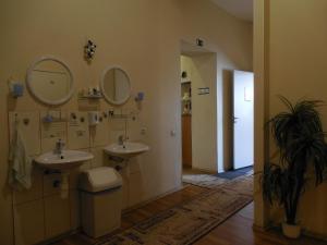 a bathroom with two sinks and two mirrors on the wall at Elizabeth's YH Rooms in Rīga +40 photos