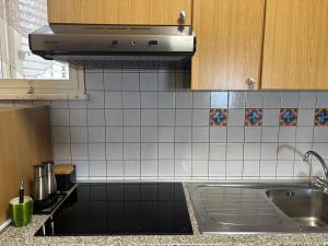 una cocina con fregadero y estufa en LA MANSARDA, en Giardini Naxos 33 fotos más