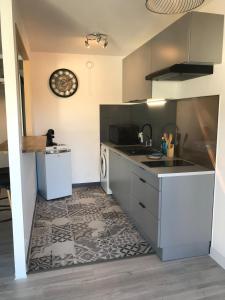 a kitchen with a sink and a dishwasher at Agréable Studio in Aurillac +7 photos