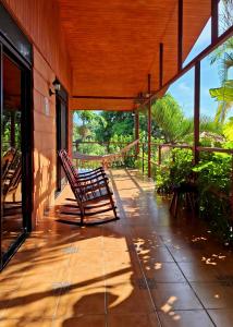 eine Veranda mit zwei Schaukelstühlen auf einem Haus in der Unterkunft Eden Atenas Costa Rica in Atenas