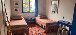 a room with two beds and a window at Hotel-Restaurant Le Kaouki in Sidi Kaouki