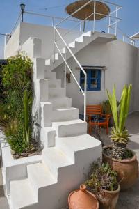 a white staircase in front of a house with plants at Hotel-Restaurant Le Kaouki in Sidi Kaouki