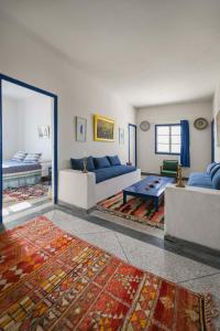 a large living room with couches and a table at Hotel-Restaurant Le Kaouki in Sidi Kaouki