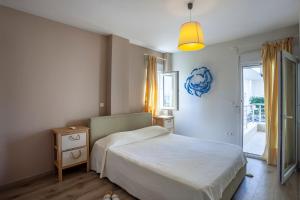 a bedroom with a bed and a door to a balcony at White Pearl in Hanioti