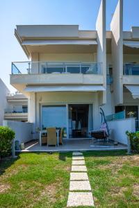 a house with a patio with a table and chairs at White Pearl in Hanioti