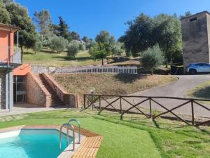 a house with a swimming pool and a fence at "Casa Parletto" - Villa Esclusiva con Piscina in Caldana