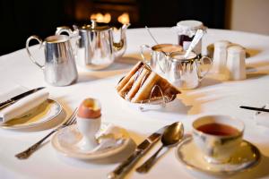 a table with a white table cloth with tea and desserts at Arbutus Hotel in Killarney