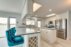 a kitchen with white cabinets and a blue chair at Waterfront Gem Crystal River Family Home in Crystal River