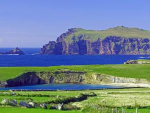 un campo verde con una montaña en el océano en Arbutus Hotel, en Killarney