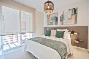 a bedroom with a bed and a large window at Sitges Spaces Deluxe Comfort Flat-Monthly Rentals in Sitges
