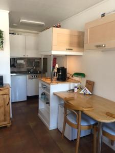 a kitchen with white cabinets and a wooden table at Apartment near the lake Gissjö, Fränsta in Fränsta +9 photos