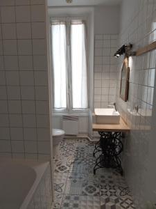 a bathroom with a sink and a toilet and a tub at La petite Parenthèse in Hauterives