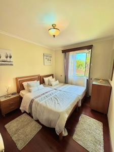 a bedroom with a large bed and a window at The Sun Edge House in Ponta do Sol