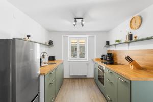 a kitchen with stainless steel appliances and wooden floors at Ferienwohnung Goltan - Zentral - Küche - WIFI in Abensberg
