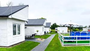 a house with a boat in the yard at Domki na Łące in Sarbinowo