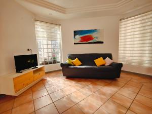 a living room with a couch and a flat screen tv at Maison Margot - Giardino e parcheggio privato in Volla