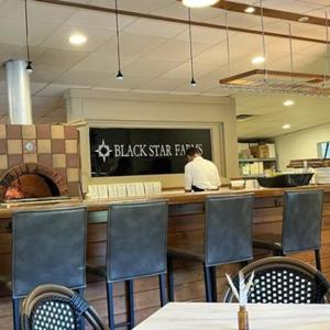a man sitting at a counter in a restaurant at Inn at Black Star Farms in Suttons Bay