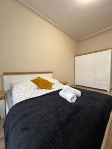 a bedroom with a bed with two towels on it at Apartament Kapitańska in Szczecin