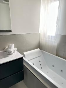un bagno bianco con vasca e lavandino di Residence Dominic a Peschici Altre 10 foto